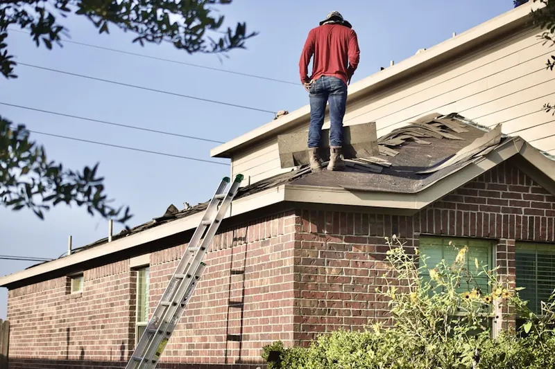 Professional roofer working on a residential roof in De Queen